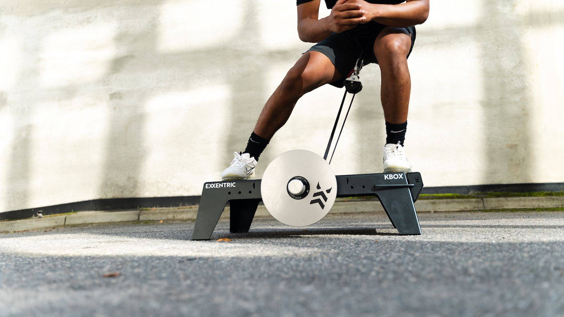 lateral_squat_on_kbox_lite_with_m_flywheel_and_platform_extension_foot_block_in_an_outdoor_setting Iberian Sportech